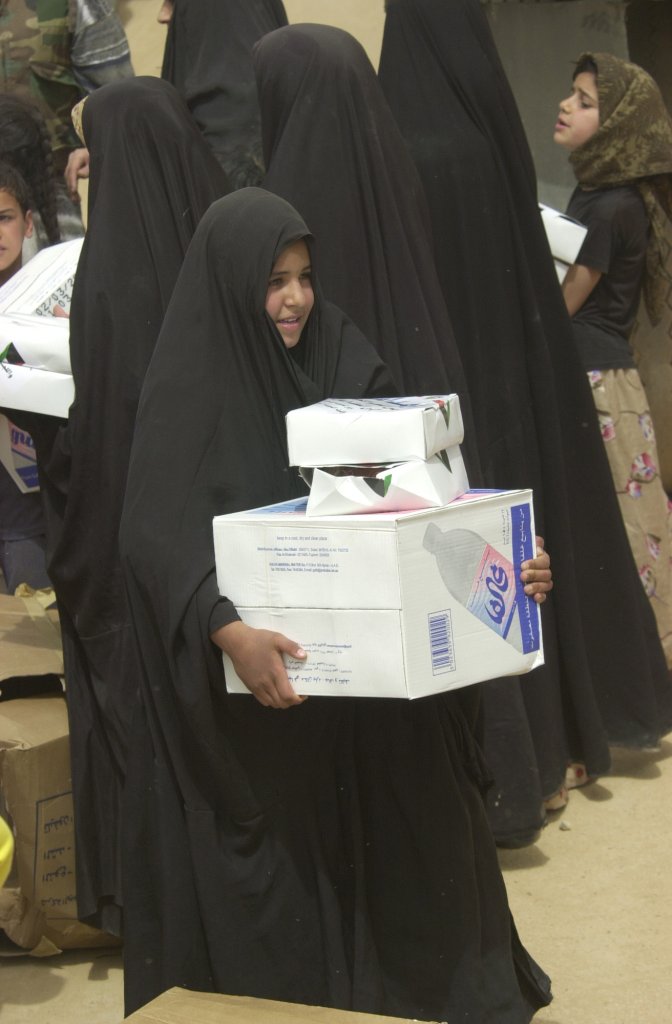 US Navy 030408-N-5362A-012 An Iraqi girl carries away a box of bottled water and humanitarian meals that were distributed by citizens of Kuwait and U.S. Army soldiers to Iraqi citizens in need.jpg